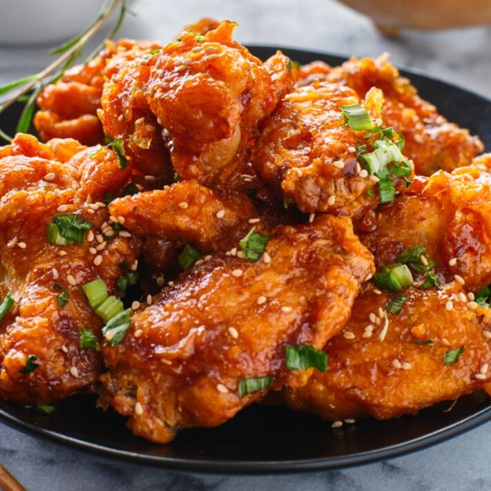 Chicken wings on a plate with with sriracha